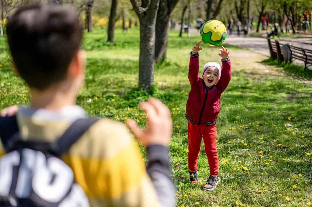 a boy reaching up to a ball