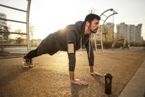 A man doing push ups outside as part of cardio workouts for men