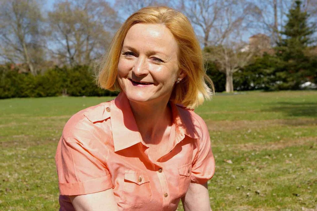 A 45- to 50-year-old woman sitting and reflecting, representing the idea that menopause means a significant phase in a woman's life.